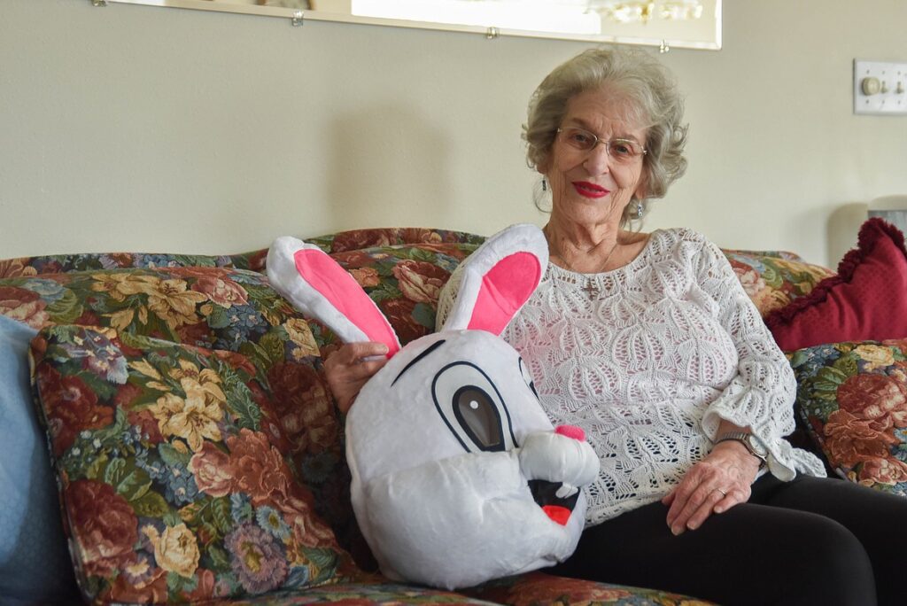 Illustration of Rose Nelson celebrating her 90th birthday in an Easter Bunny costume, surrounded by loved ones, spreading joy and laughter at a festive community event.